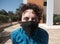 Brazilian Curly hair woman using mask on a Sunny Day during the quarantine