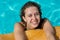 Brazilian Curly haired woman relaxing at the pool looking at the camera