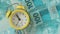 Brazilian currency, Banknotes put on the desk next to the alarm clock set for five to twelve, time is money c