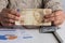 Brazilian currency: Real. Person handling papernotes on desk. Retired woman holding bill on desk office