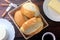 Brazilian French bread, in basket, on rustic wooden table for breakfast