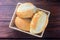 Brazilian French bread, in basket, on rustic wooden table for breakfast