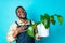 brazilian gardener man holding garden items in studio blue background