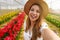 Brazilian girl laughing taking self portrait between tulips. Content creator showing greenhouse on springtime in her stories on