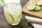 Brazilian lemon caipirinha in a glass with ice with fruit slices over wooden board