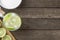 Brazilian lemon caipirinha in a glass with ice with fruit slices over wooden board  with copy space