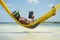 Brazilian Man Relaxing with Tablet in Beach Hammock