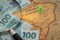 Brazilian money, 100 reais scattered on the map of South America with the green point of Brazil marked