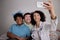 Brazilian multiracial friends having a break for a selfie photograph all together in small apartment at living room Playful