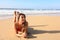 Brazilian smiling beautiful girl lying down on sand enjoying sun tanning sunbathing in swimsuit relaxing on Canary Island tropical