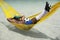 Brazilian Soccer Player Relaxing with Football in Beach Hammock