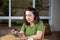 Brazilian tattooed woman sitting next to a cup of coffee and interacting with her smartphone