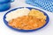 Brazilian tenderloin stroganoff with rice and potato sticks in a blue plate in white background