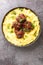 Brazilian traditional food stewed oxtail Rabada with corn polenta closeup on plate. Vertical top view