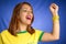 Brazilian woman fan celebrating on football match on blue background.