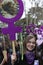 Brazilian woman holding banner with the feminist symbol and portrait of a woman victim of gender violence during the Women`s Day