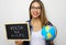 Brazilian young female teacher holding globe and blackboard with portuguese written