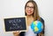 Brazilian young female teacher holding globe and blackboard with portuguese written `Volta as aulas` Back to school