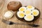 Bread, bowl with mayonnaise, brown saucer with halves boiled eggs, fork on table