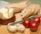 Bread and butter/Delicious organic home-made bread and butter with ripe tomatoes on wooden board.