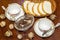 Bread, chocolates and two cups on a polished table. top view