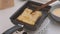 Bread croutons in an egg are fried in a pan. Close-up. Fried bread slices with milk for breakfast.