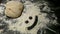 Bread dough with a smiley face in flour.