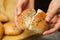 Bread in hands of woman. baker`s hand breaking freshly baked sesame bun