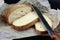 Bread Knife Slice. Sourdough Loaf sliced with bread knife. Freshly baked bread with kitchen towel and knife