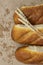 Bread loaves on craft paper with wheat ears and grain, close-up