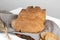 The bread of Matera, Pane di Matera on linen napkin on white wooden background, typical southen italian sourdough bread