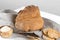 The bread of Matera, Pane di Matera on linen napkin on white wooden background, typical southen italian sourdough bread