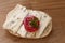 bread roll with mould cheese, tomato and parsley garnish on a wooden board, top view from above