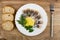 Bread, salted herring with lemon, parsley and dill in plate, fork on table . Top view