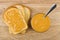 Bread, sandwich with peanut butter, bowl and teaspoon on table