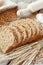 Bread slices, rolling pin, grain and rye ears on table