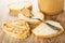 Bread, spoon with peanut butter on slice of bread, jar with peanut butter, sandwich on wooden table