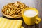 Bread sticks in wicker basket, milk, yellow napkin on table