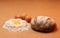 Bread, three eggs and an egg yolk surrounded by flour