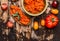 Bread with vegetable tomatoes spread on rustic wooden background, top view