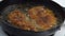 Breaded Chicken Frying in a Cast Iron Pan Up Close