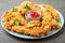 Breaded chicken strips with tomato ketchup on a white plate. Fast food on dark brown background