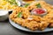 Breaded chicken strips with tomato ketchup on a white plate. Fast food on dark brown background