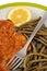 Breaded meat served with vegetables in a plate close-up