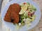 Breaded salmon with lemon and Greek salad