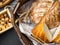 breads in baskets, variety baking products on wooden surface