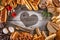 Breads, pastries, christmas cake on wooden background with heart, picture for bakery or shop, valentines day