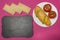 Breadstones on a pink background, a plate with a sandwich and tomatoes, a signboard, a breakfast for the child in school