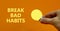 Break bad habits symbol. Businessman holds yellow shining light bulb. Words `Break bad habits`. Beautiful orange background.