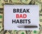 Break bad habits symbol. Words `Break bad habits` on white note. Beautiful background from dollar bills, metallic pen. Business,